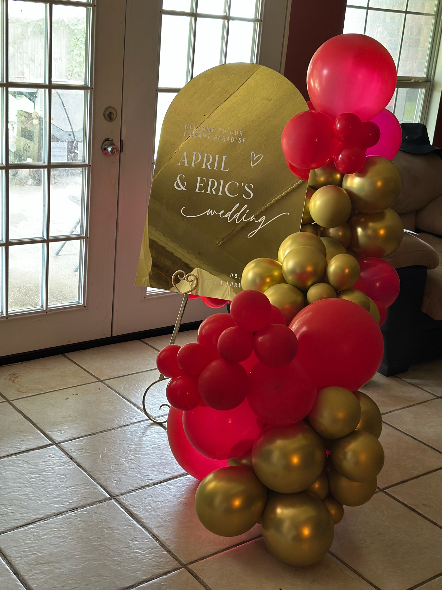 April & Eric wedding welcome sign with red & gold garland